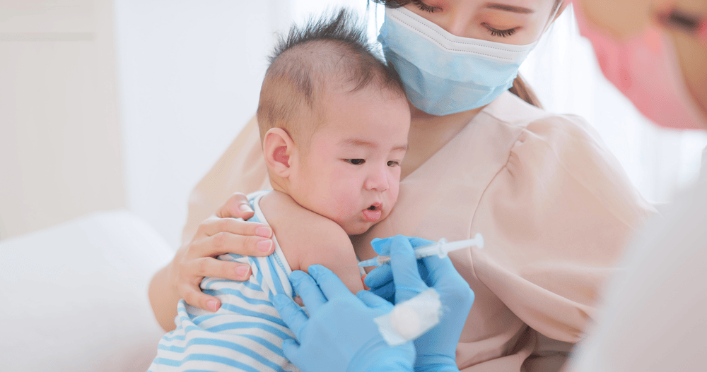Hình ảnh mẹ và bé tại trung tâm tiêm chủng, kiểm tra lịch tiêm chủng cho bé.